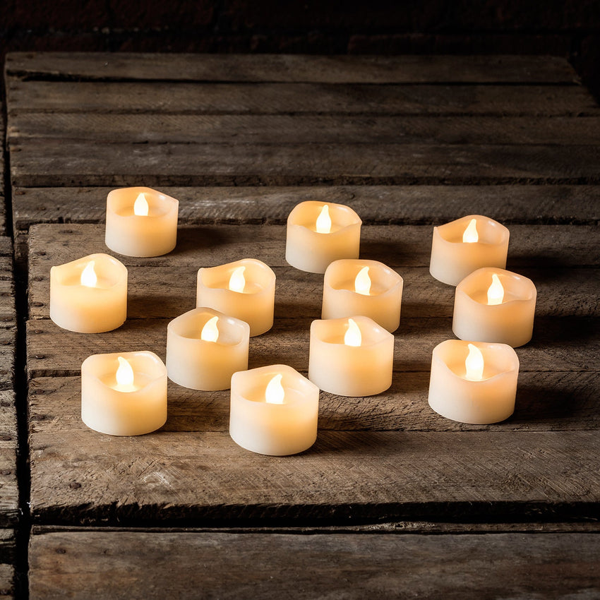 Set of twelve indoor LED votive candles on a wooden surface
